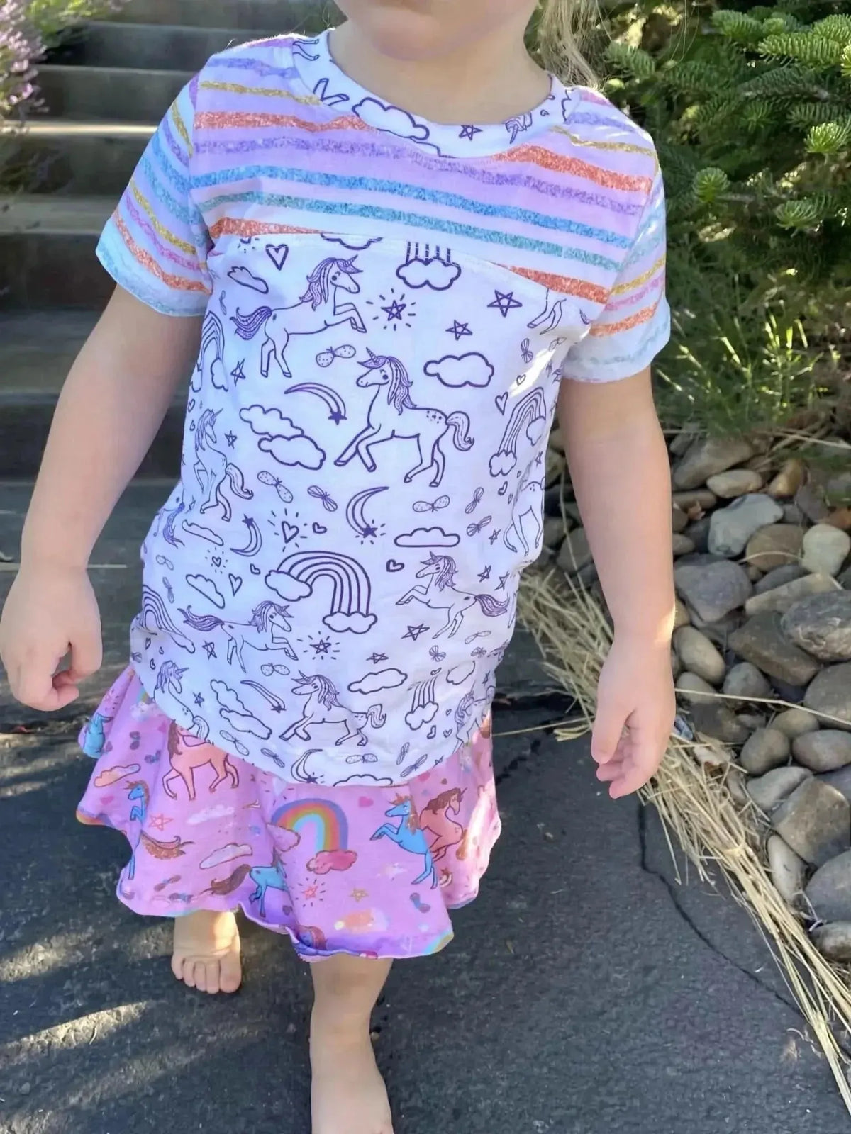 Pink unicorn sparkle print fabric with unicorns, rainbows, and stars on a white background.