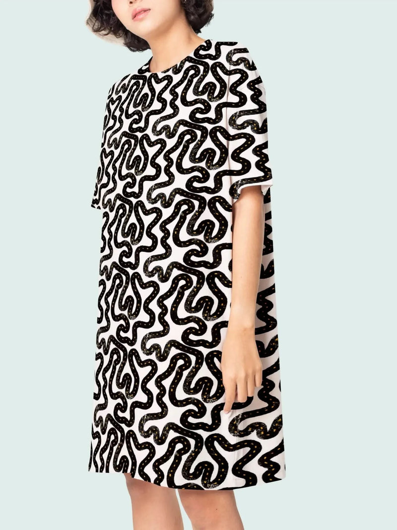 A woman wears a white dress with a black and yellow road pattern.