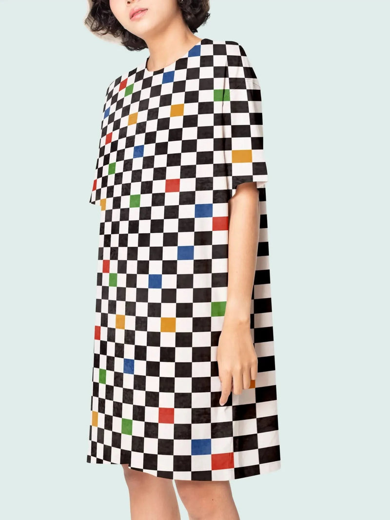 A woman wears a black and white checkered dress with colorful squares.