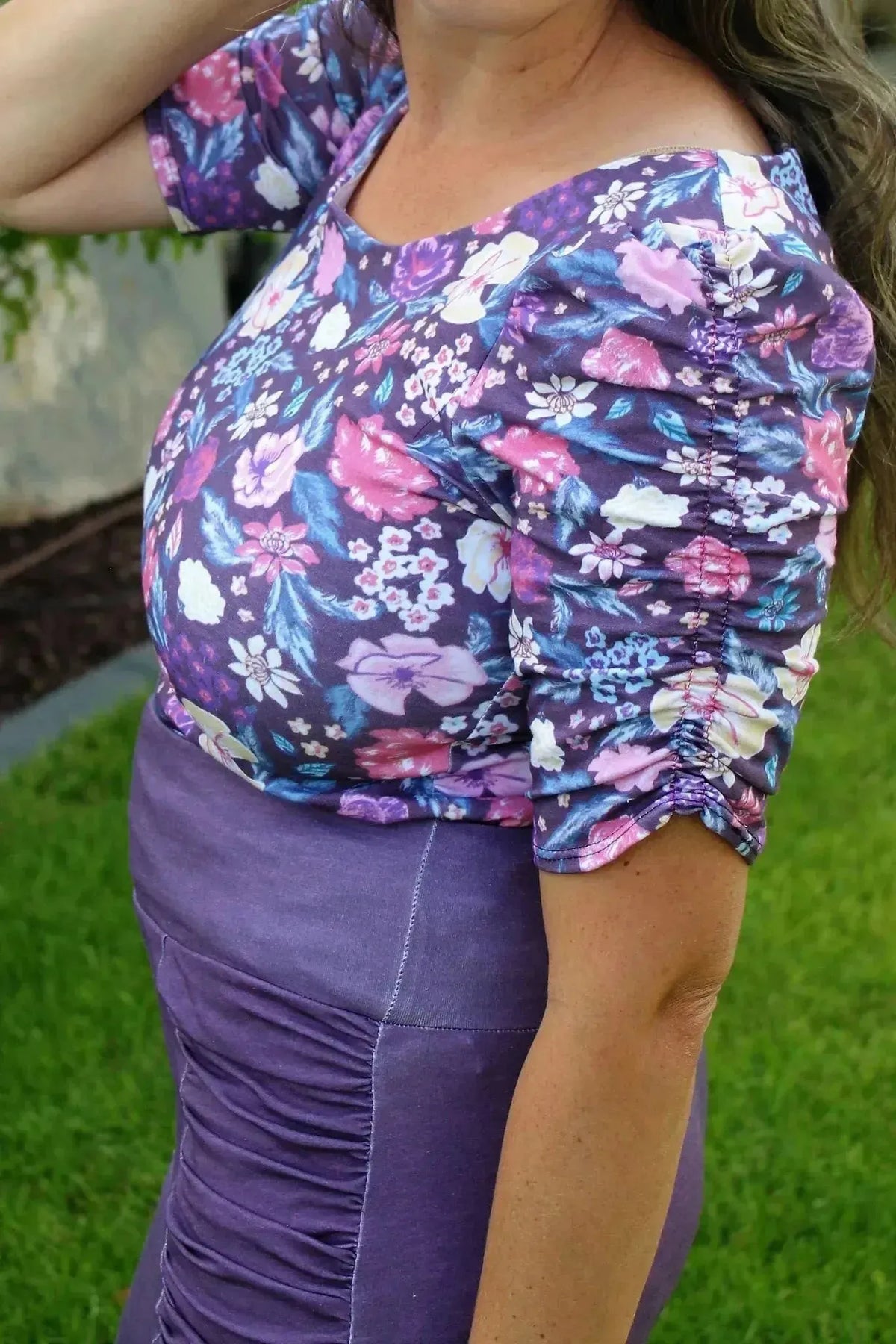 Maroon floral print fabric with botanical garden theme, shown in a sewn garment.