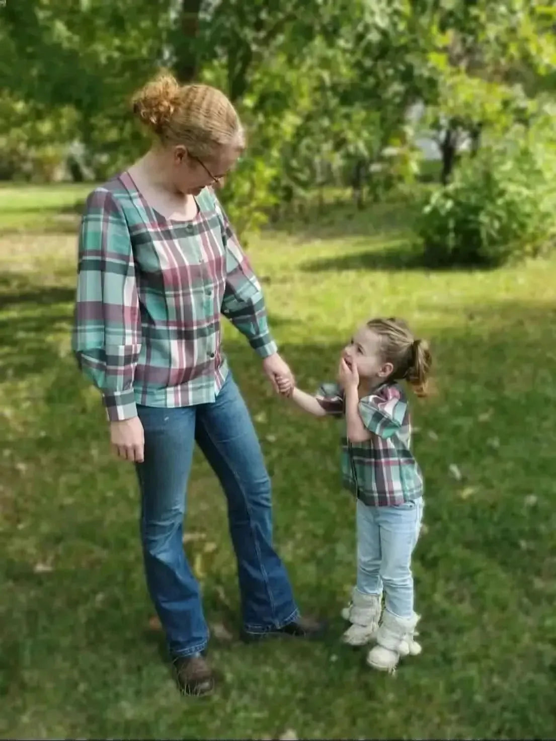 Teal and purple plaid holiday fabric shown in matching mother-daughter outfits.