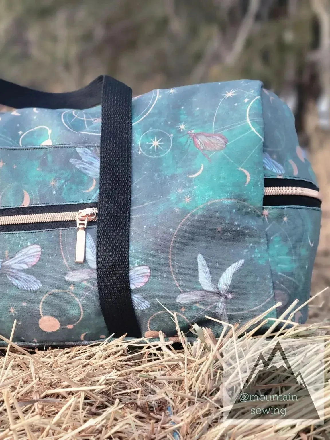 Celestial dragonflies print on green fabric with moons and circles.