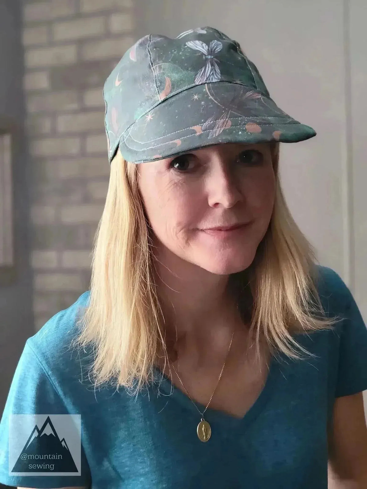 Green fabric with celestial dragonfly print, shown as a woman's bucket hat.