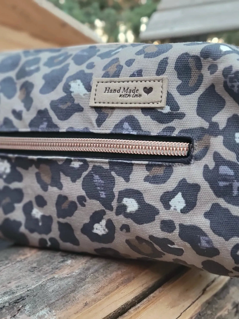 Leopard print pouch with a rose gold zipper and a "Hand Made with Love" tag.