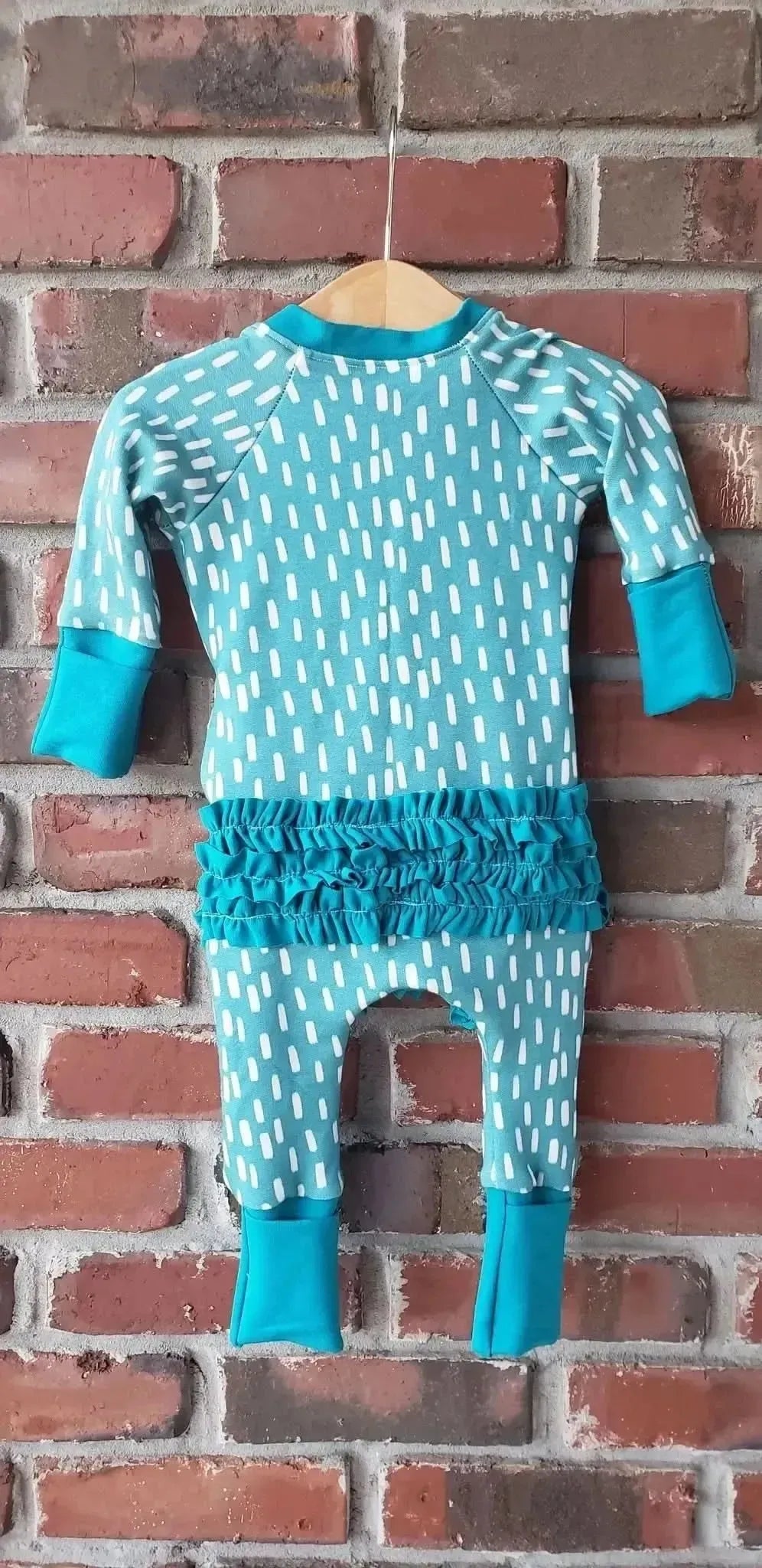 Blue dash pattern print fabric from WayMaker Fabrics, shown in a sewn baby romper.