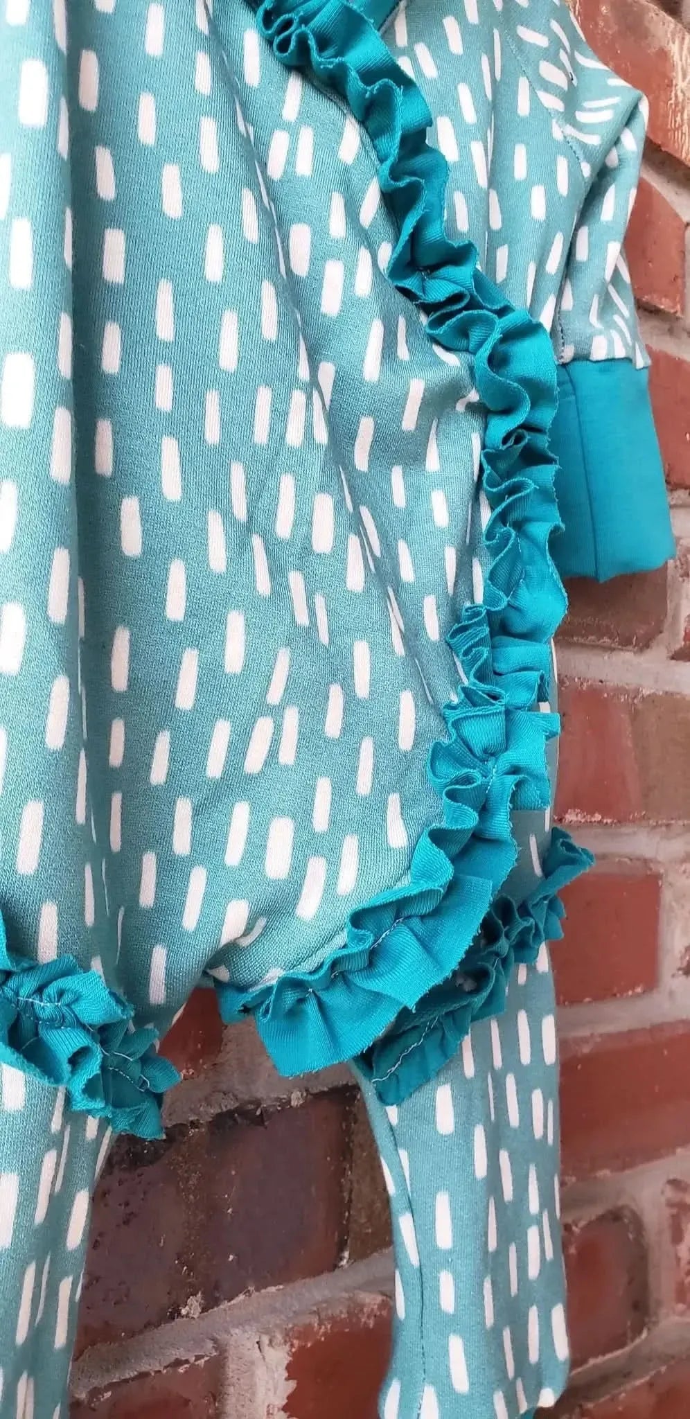 Blue fabric with white dash pattern and teal ruffles.