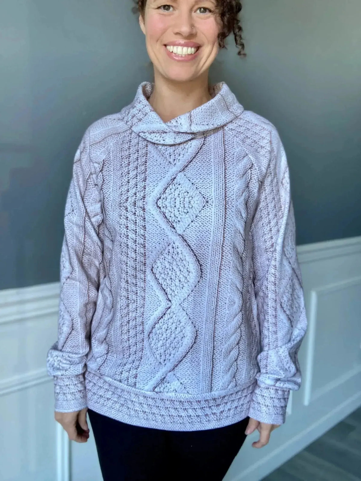 Cream cable knit fabric in light color, shown as a mockup sweater on a model.