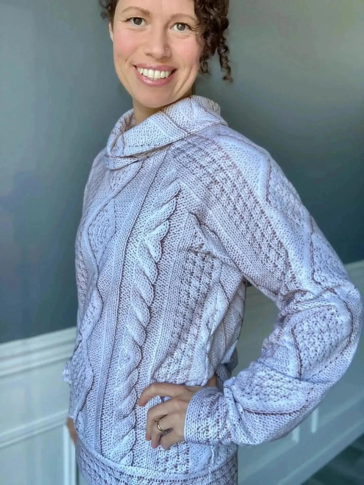 Cream cable knit fabric in a light color, shown as a sewn sweater on a model.