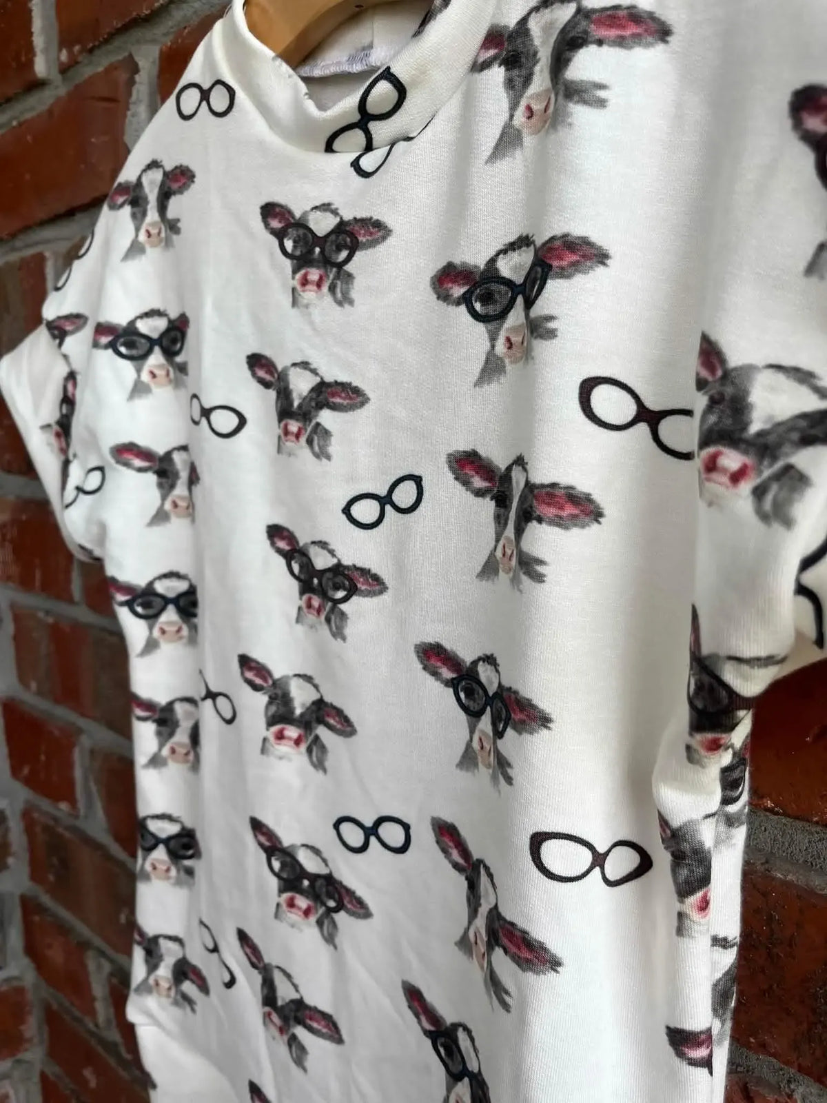 White fabric with a pattern of cows wearing glasses.