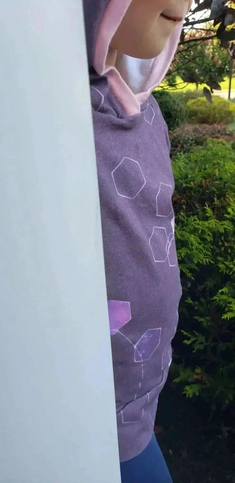 Burgundy fabric with a geometric hexagon print, worn as a hoodie and pants.