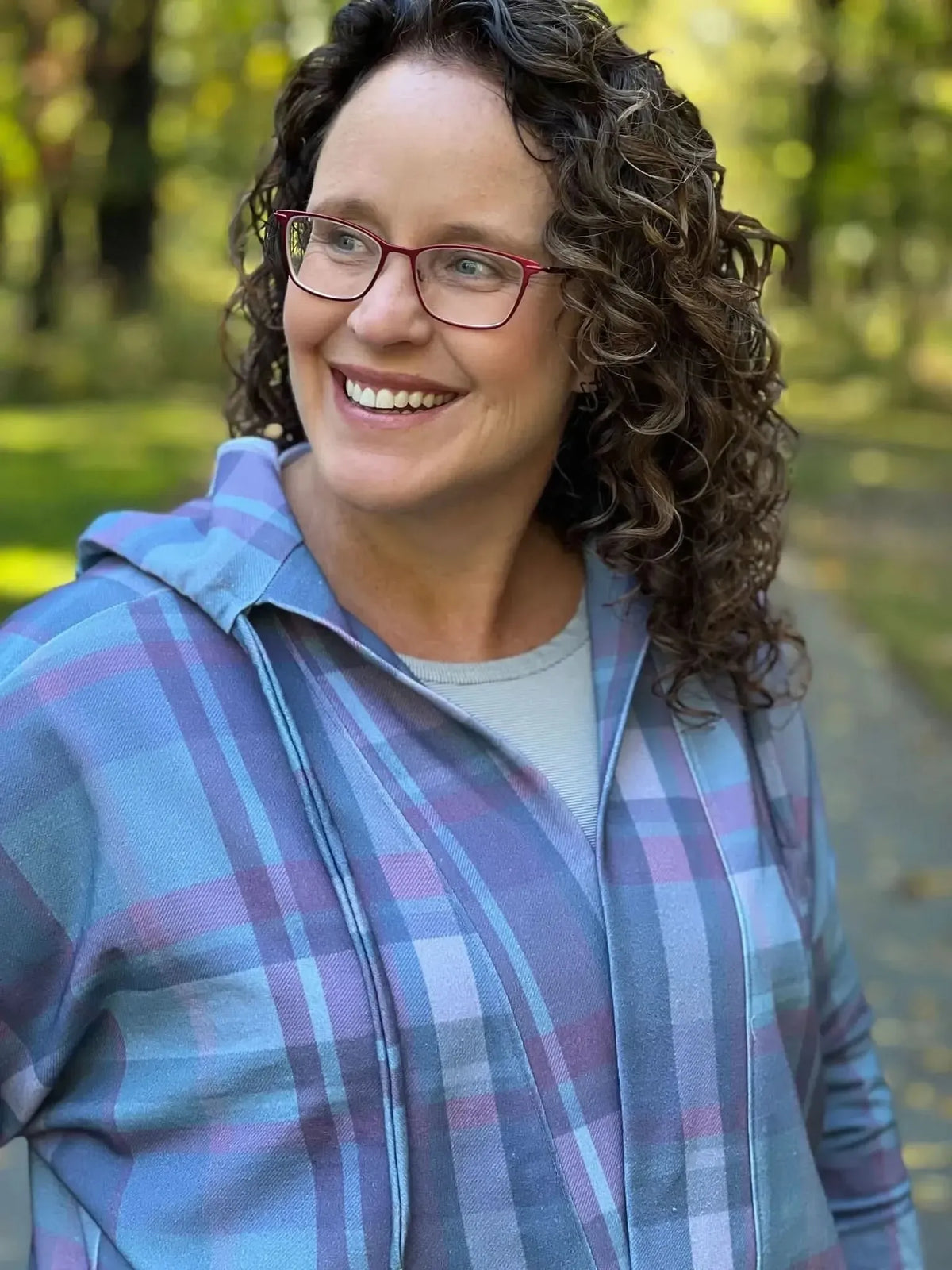 A woman wearing a blue and purple plaid hooded jacket.
