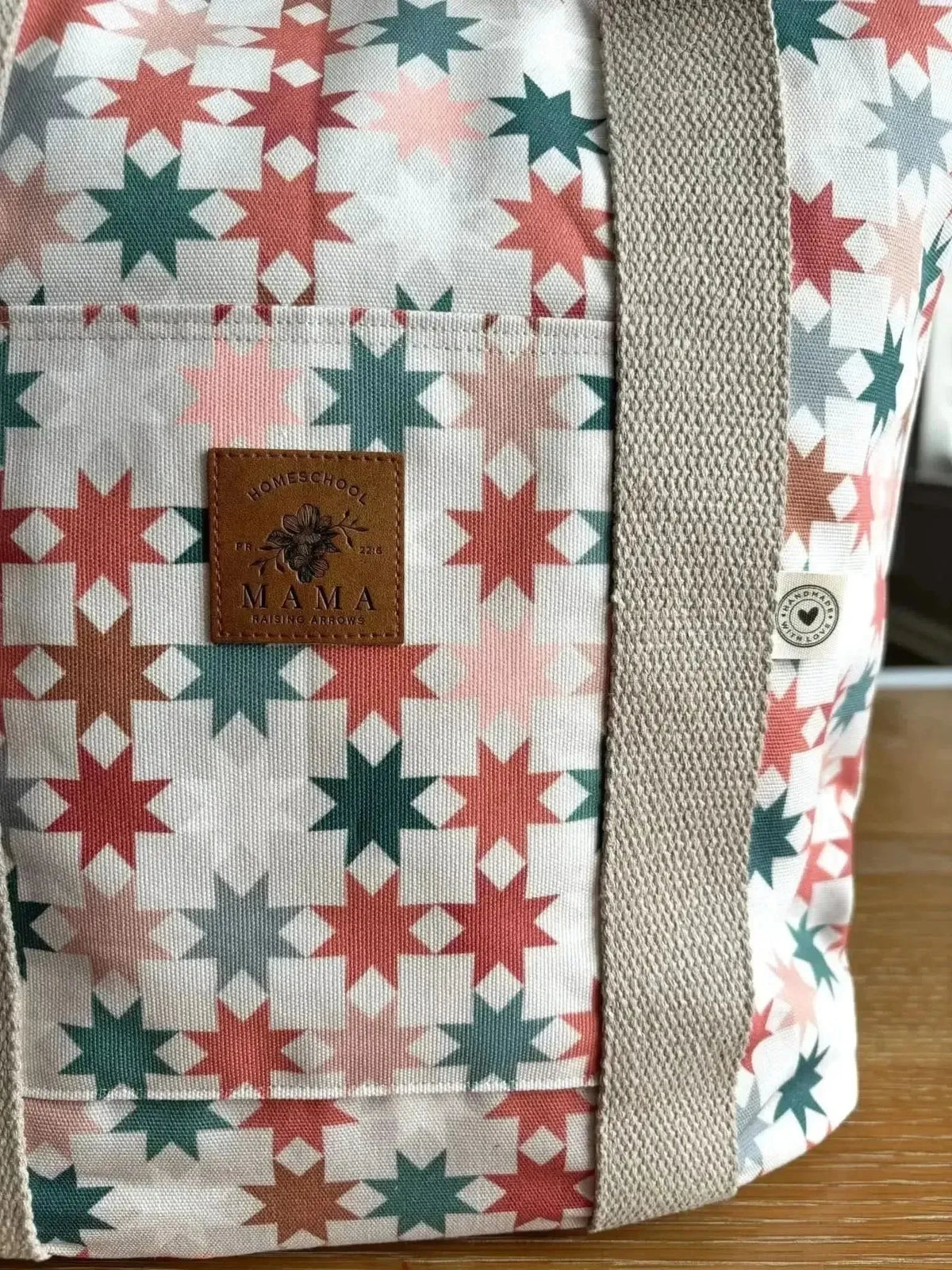 White fabric with pink, red, and green geometric star pattern.