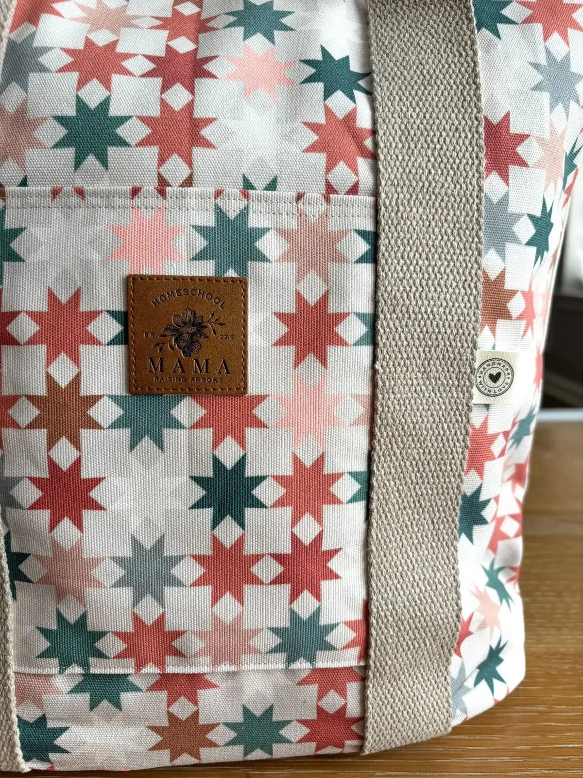 White fabric with pink, red, and green geometric star pattern.