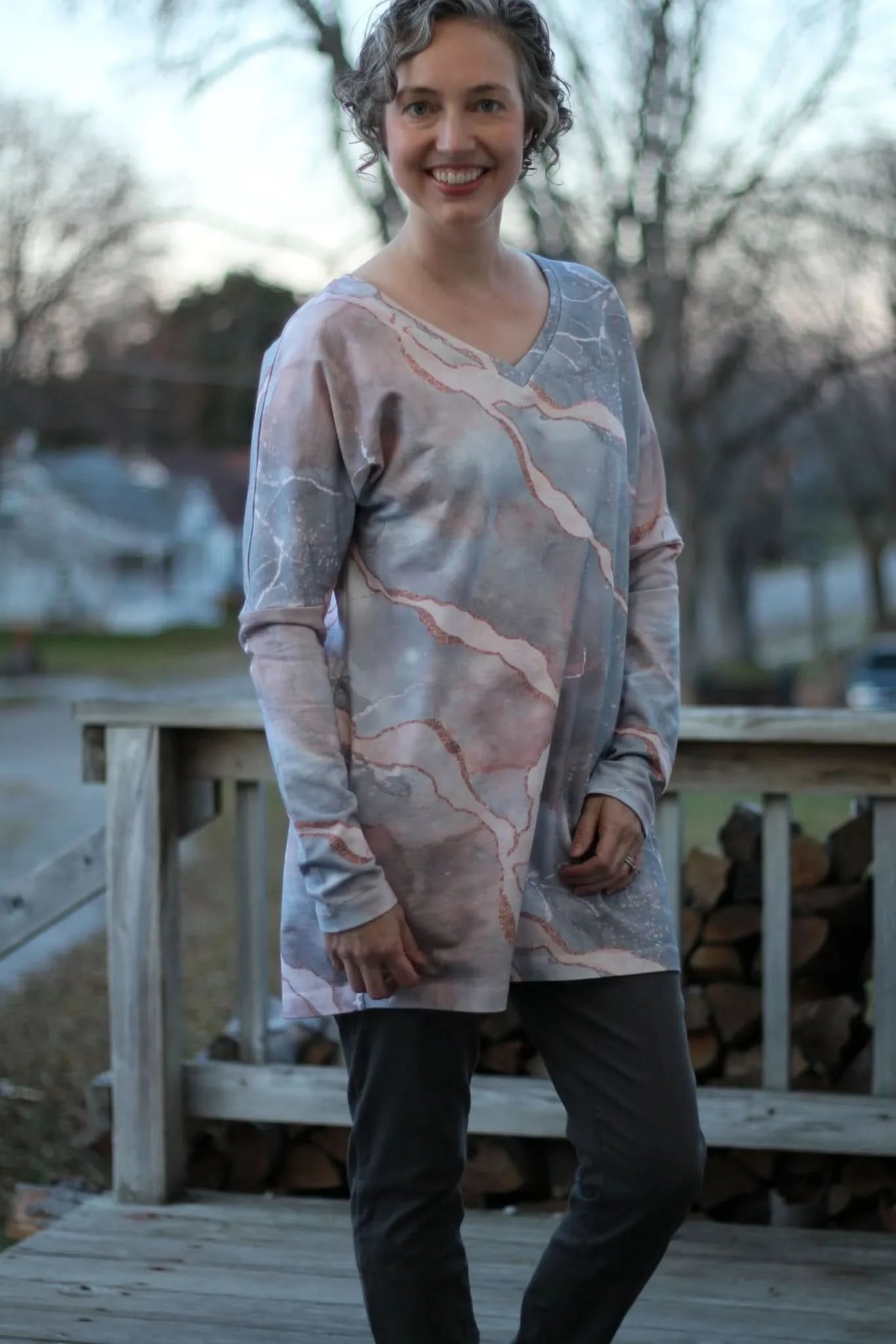 A woman wears a long-sleeved shirt with a pink and gray marble pattern.