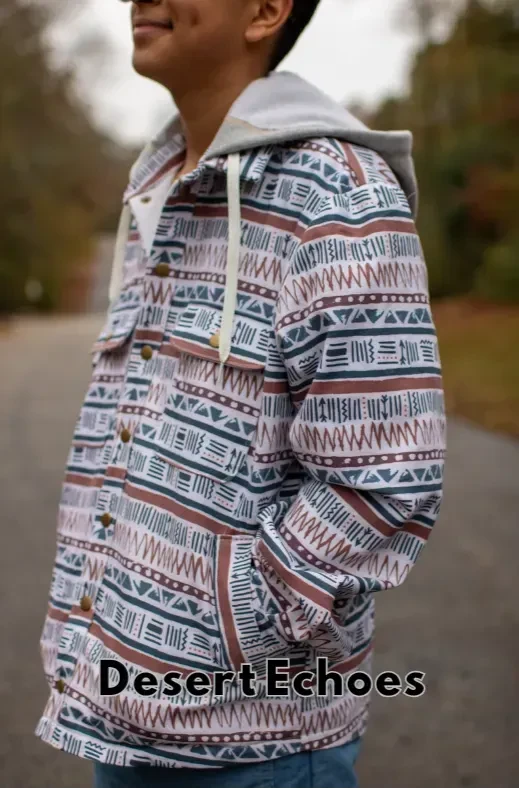 A person wearing a hooded jacket with a brown, teal, and white geometric pattern.