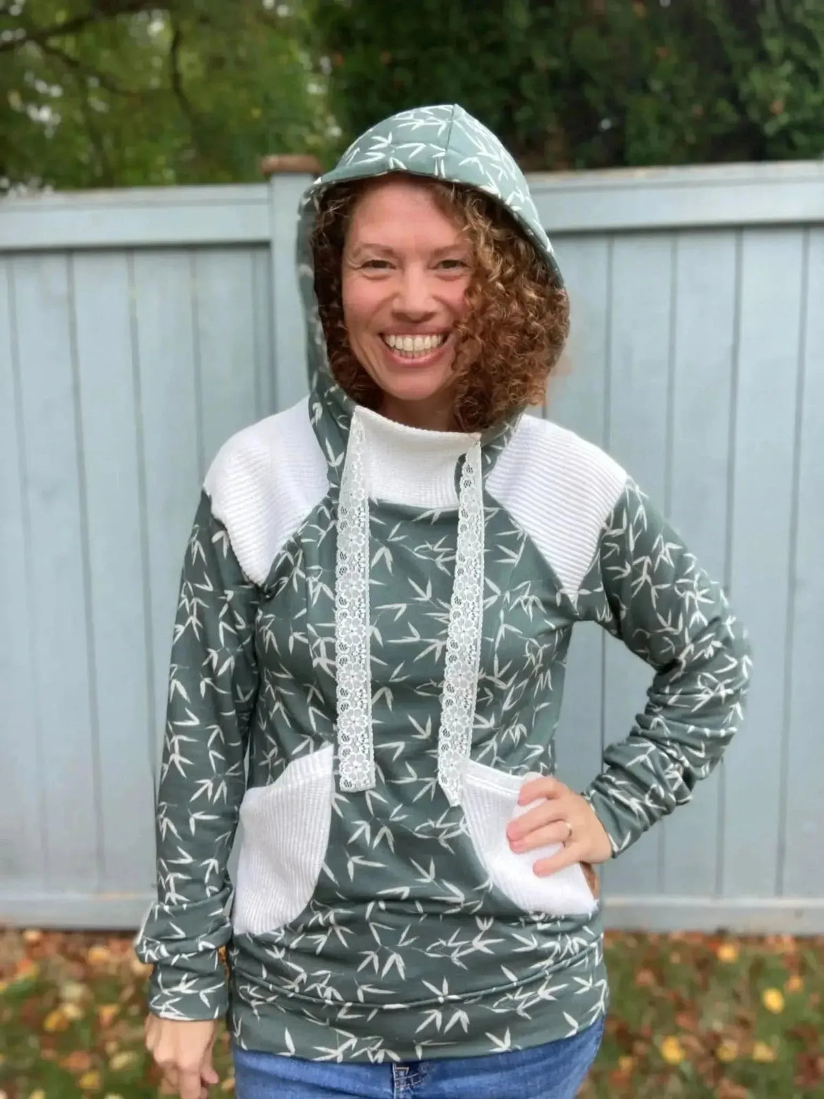 Green hooded sweatshirt with white panels and bamboo leaf print.