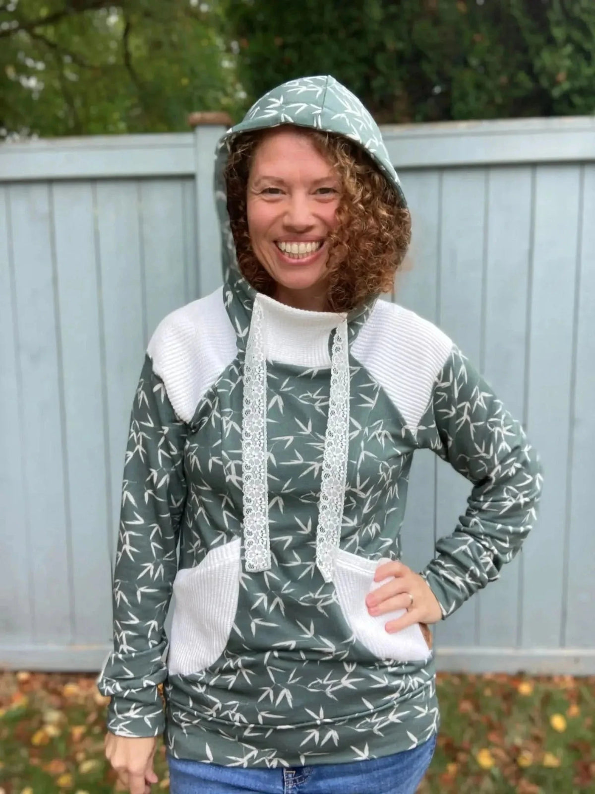 Green hooded sweatshirt with white panels and bamboo leaf print.