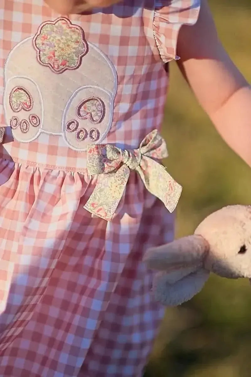 Tan gingham fabric with pink checkered pattern and embroidered floral details.
