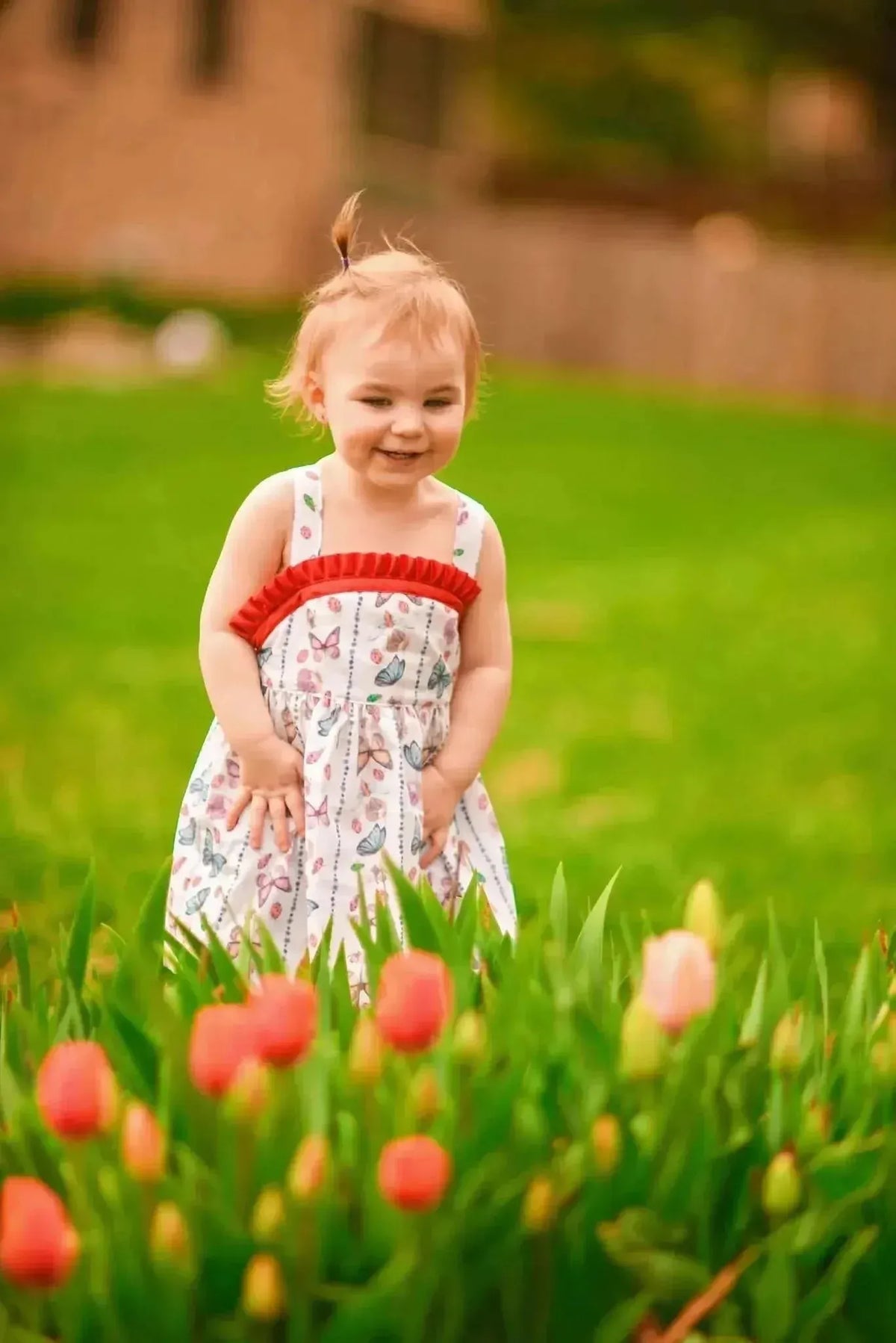 White fabric with red buggy stripes and insect theme, shown in a child's sundress.