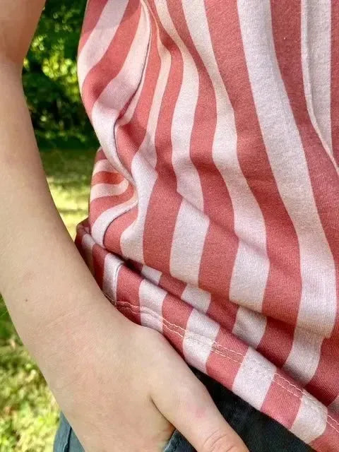 Close-up of Earthen Path striped fabric in neutral warm tones on a model outdoors.