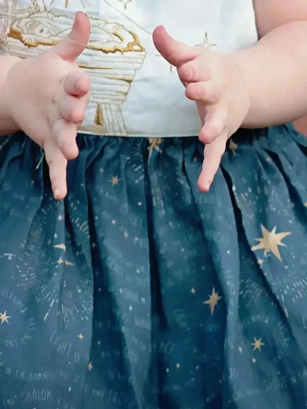 Blue fabric with gold celestial stars and a nativity scene print.