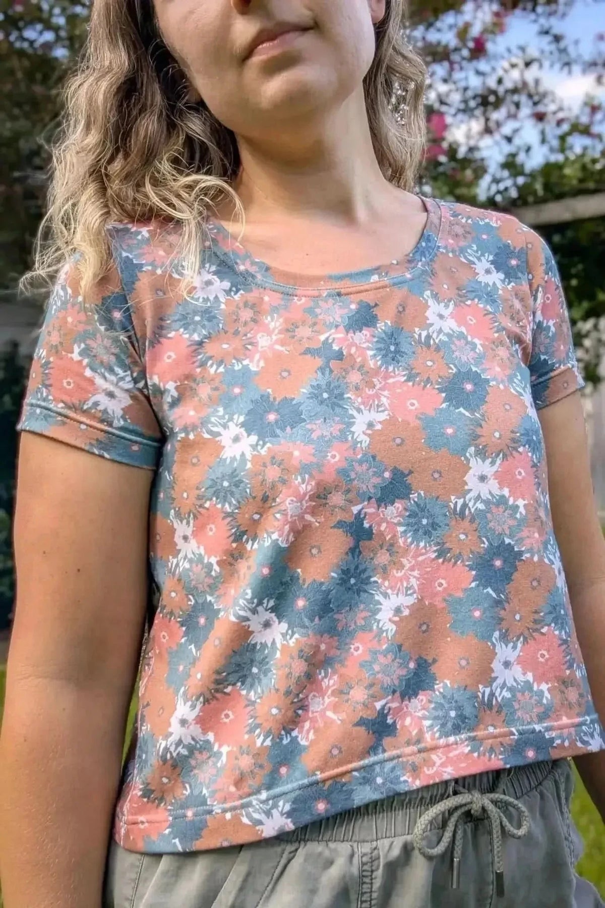 Floral print craft fabric in blue and orange tones on a white background.