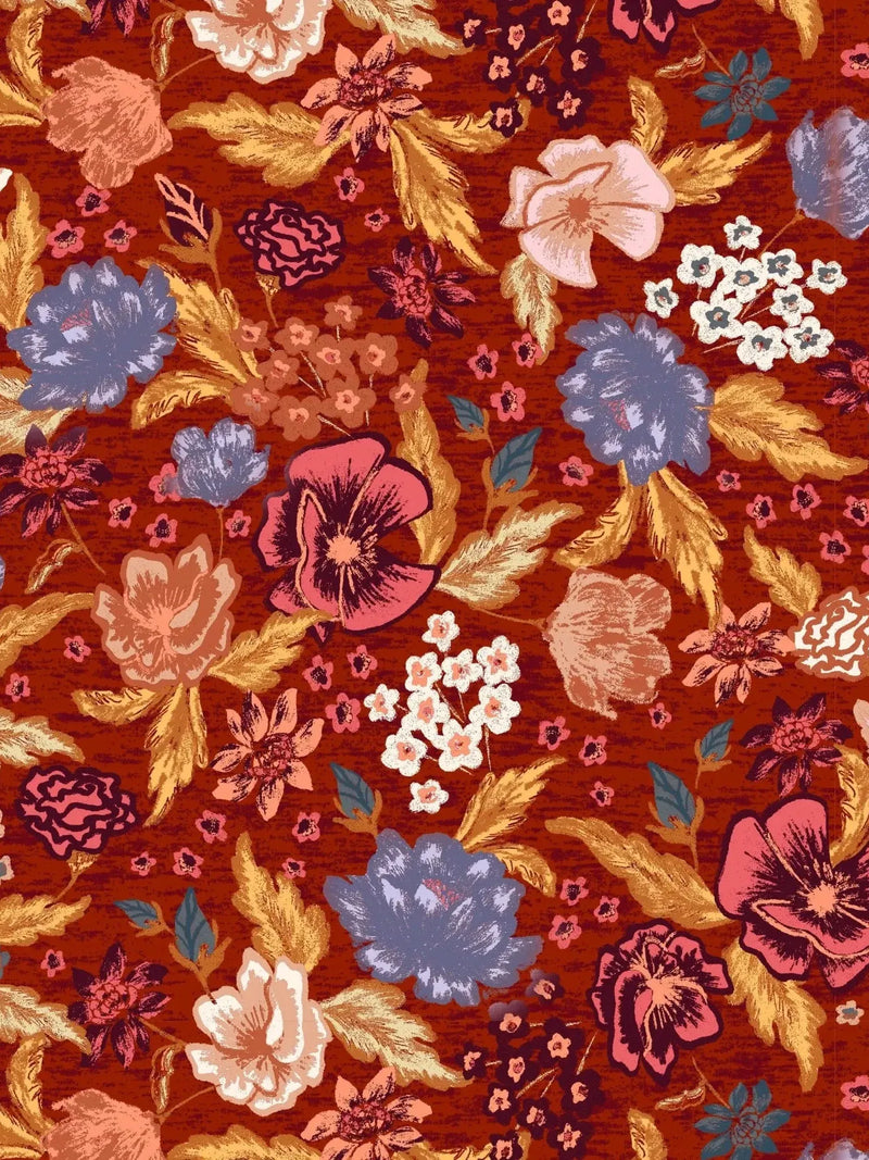 A fabric with a pattern of various colorful flowers and leaves on a red background.