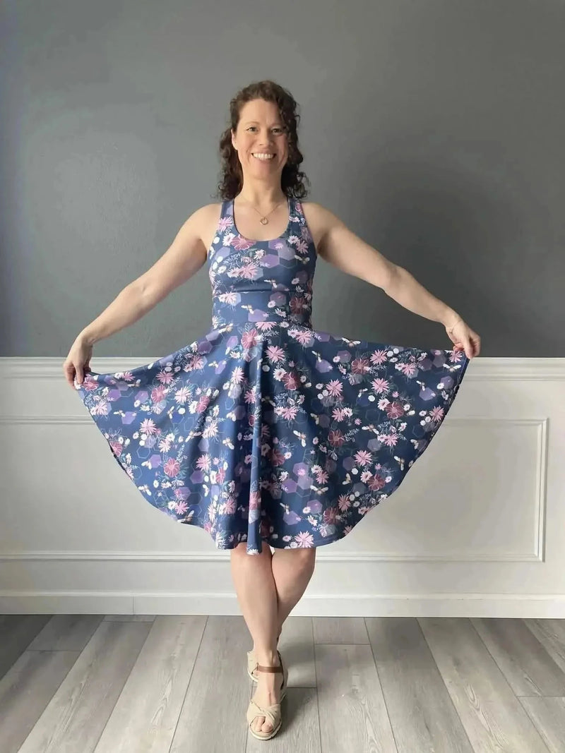 Purple fabric with garden bees print, shown as a flared sleeveless dress on a model.