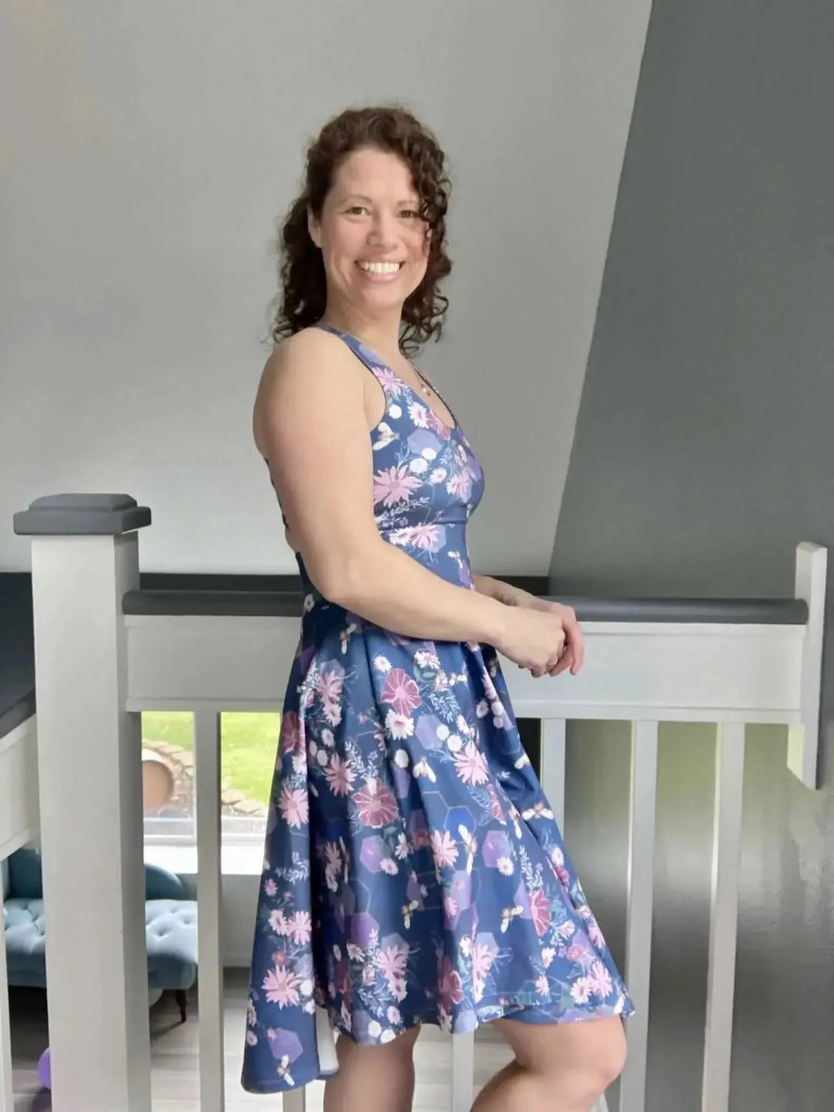 Purple fabric with garden bee print, shown as a sleeveless floral dress on a model.