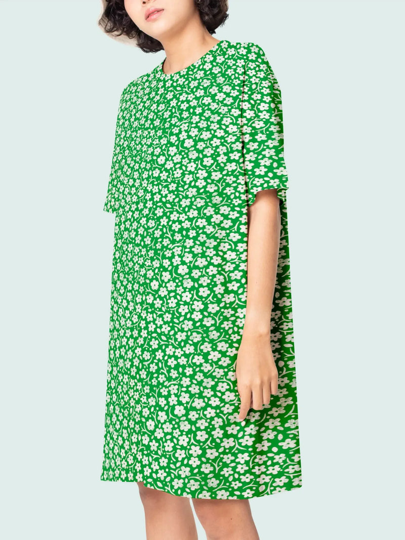 A woman models a green floral dress with short sleeves.