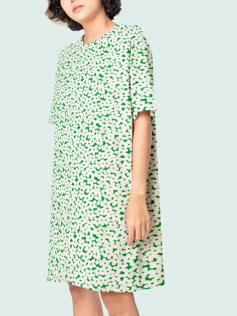 A woman wears a green and white floral print dress.