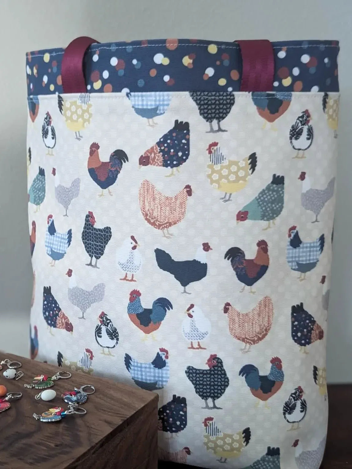 A fabric storage bin with a colorful chicken pattern and a wooden box with charms.
