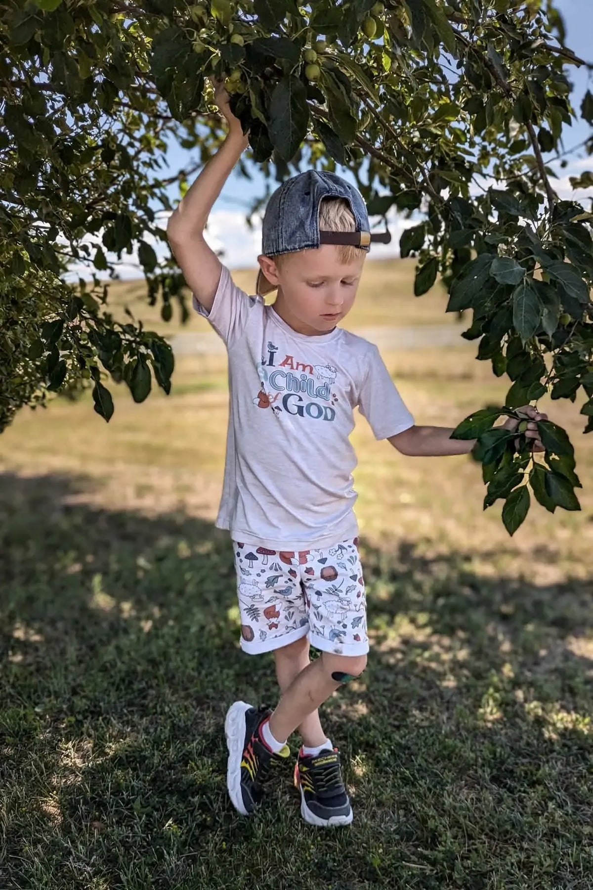 A young boy wears shorts with a woodland creature pattern.