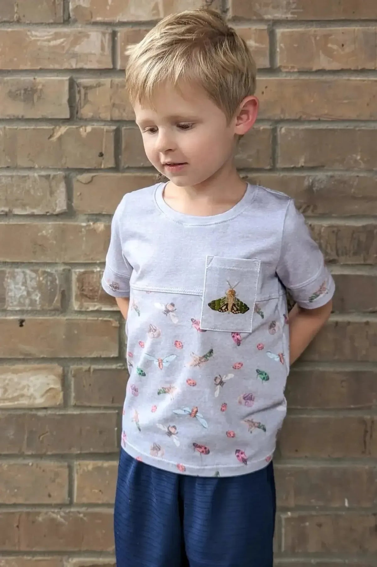 Light grey quilting cotton fabric with colorful bug print pattern.