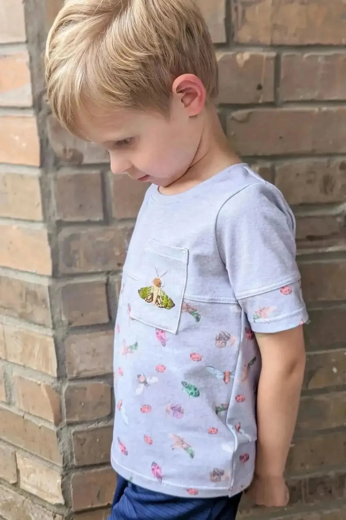 Light grey quilting cotton fabric with colorful bug print pattern.