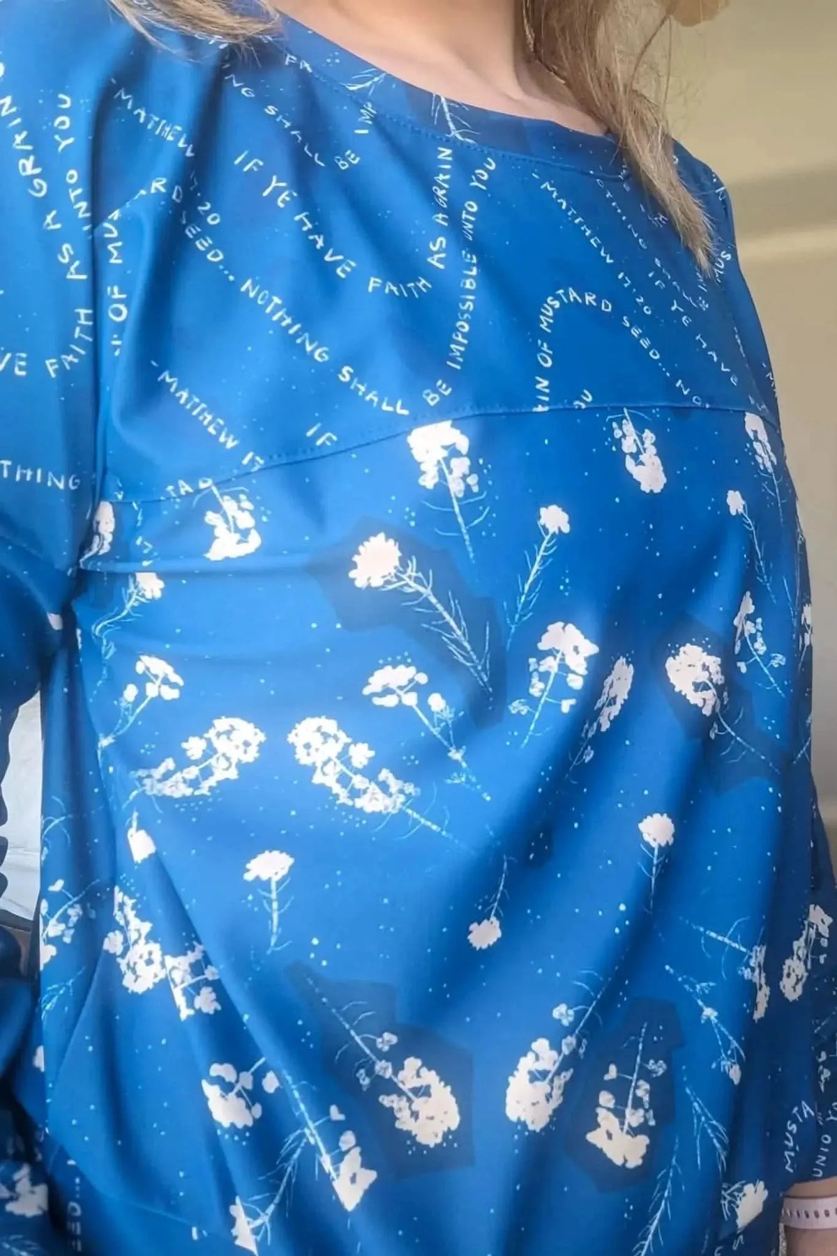 Blue fabric with white text and floral patterns.