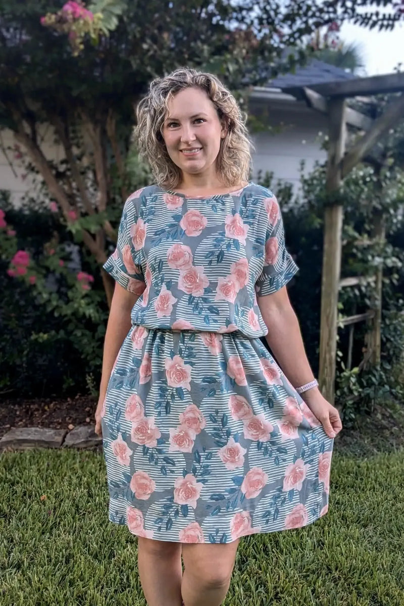 A woman wears a dress with a wild rose and stripe pattern.