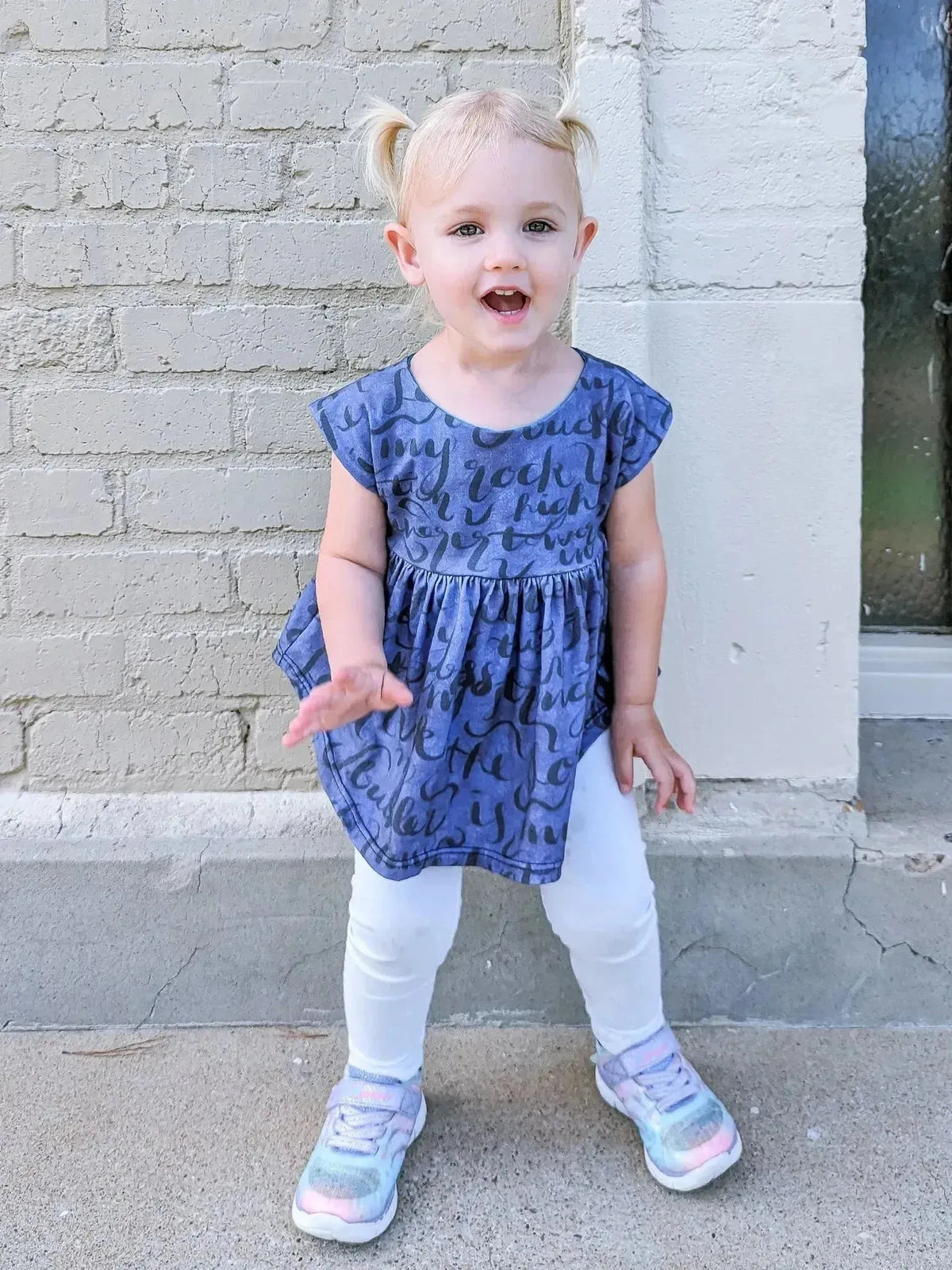 A young child wears a blue top made from My Rock Winter Psalm 18:2 Faith Based Fabric.