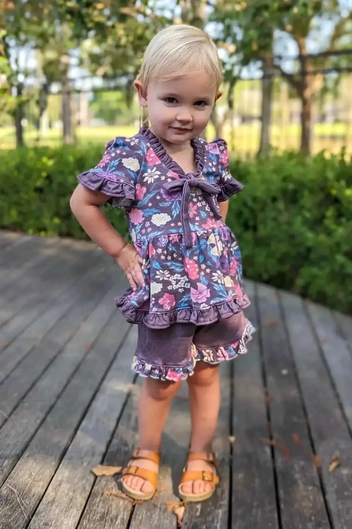 Maroon floral print fabric with botanical garden theme on a young girl in a park.