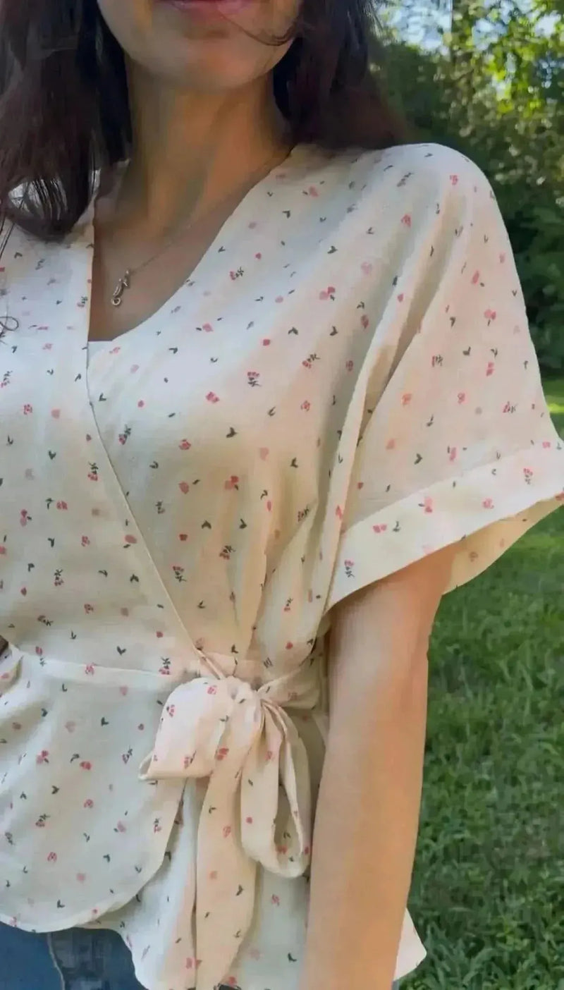 Blush floral printed fabric with pink and white flowers on a light background.