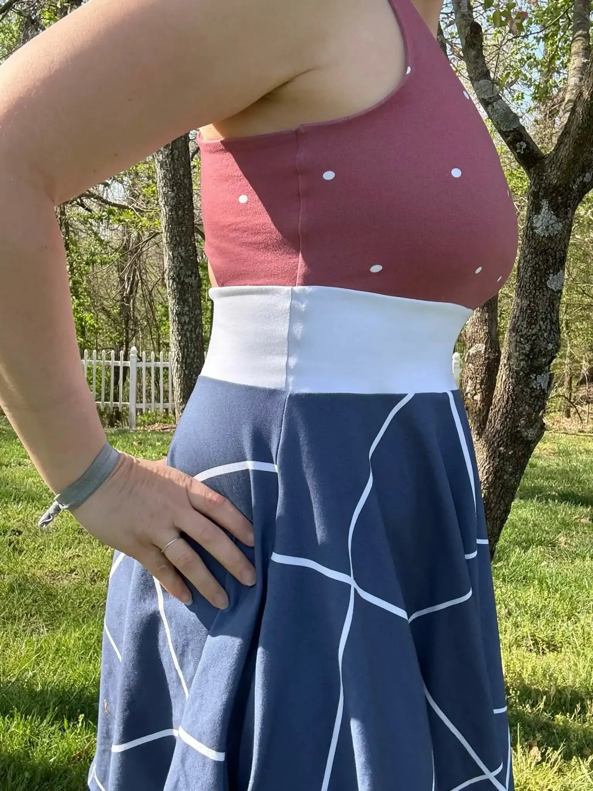 A person wears a dress made from navy windowpane fabric and a polka dot top.