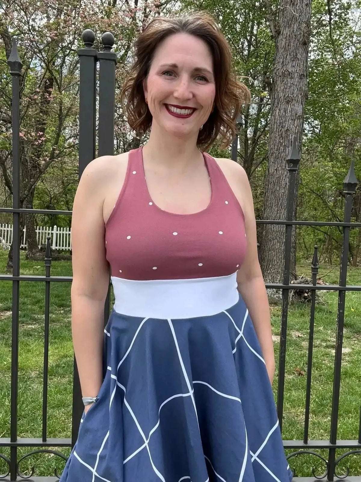 Navy windowpane geometric pattern fabric in a full skirt with white waistband and pink tank top.
