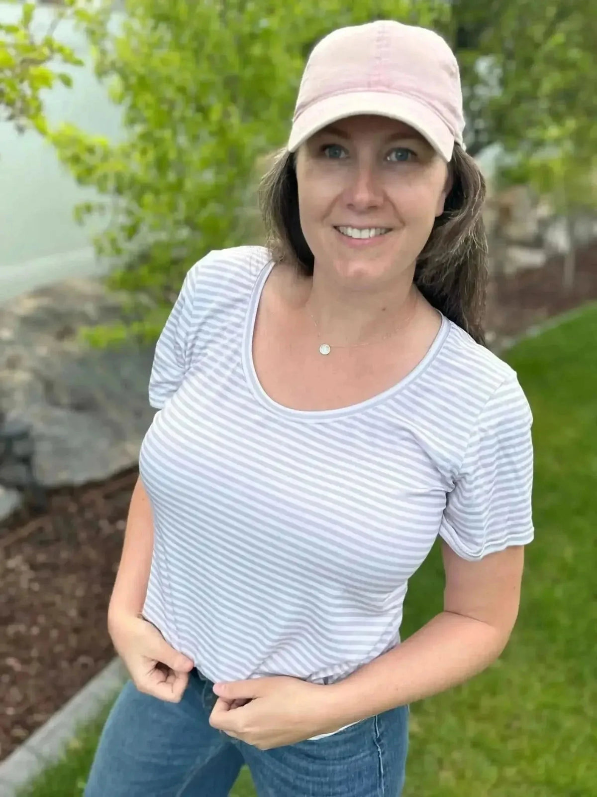 Tan striped fabric swatch shown on a model wearing a fitted V-neck T-shirt outdoors.