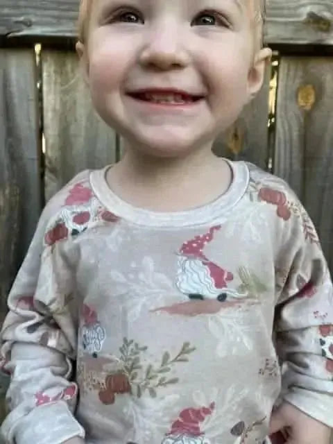 Tan fabric with autumn holiday gnome and toile print in soft beige tones.