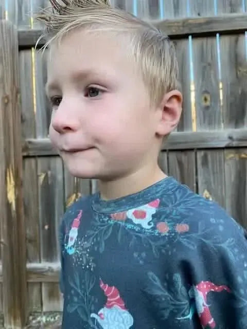 Green holiday fabric featuring gnome toile pattern with red hats and foliage.