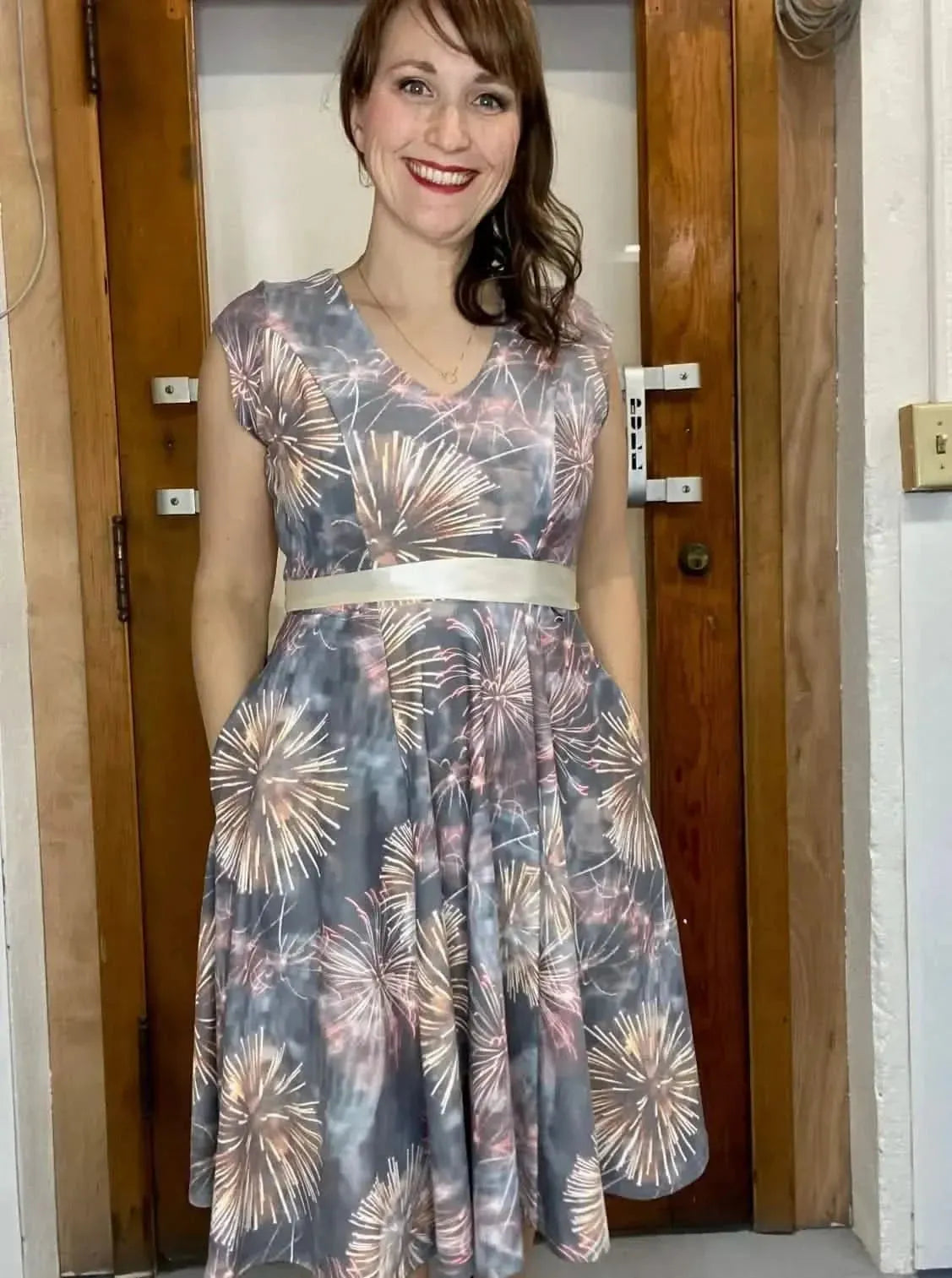 Celebration fireworks print fabric in festive holiday theme, shown as a gray dress.