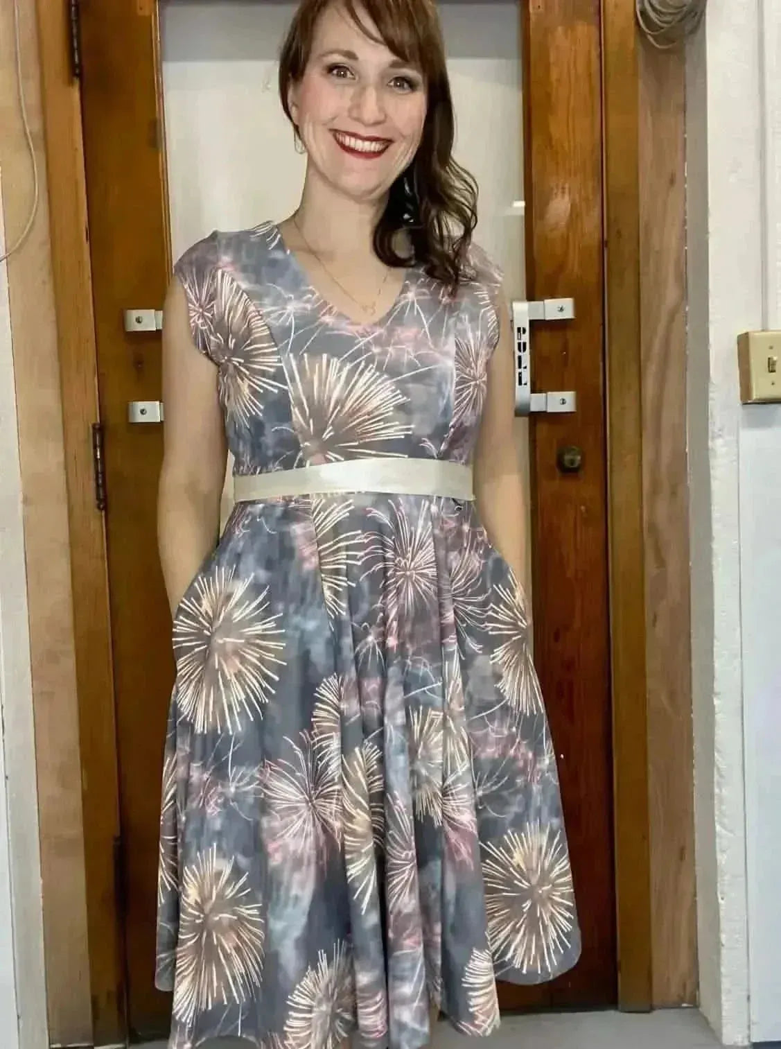 Celebration fireworks print fabric in festive holiday theme, shown as a gray dress.