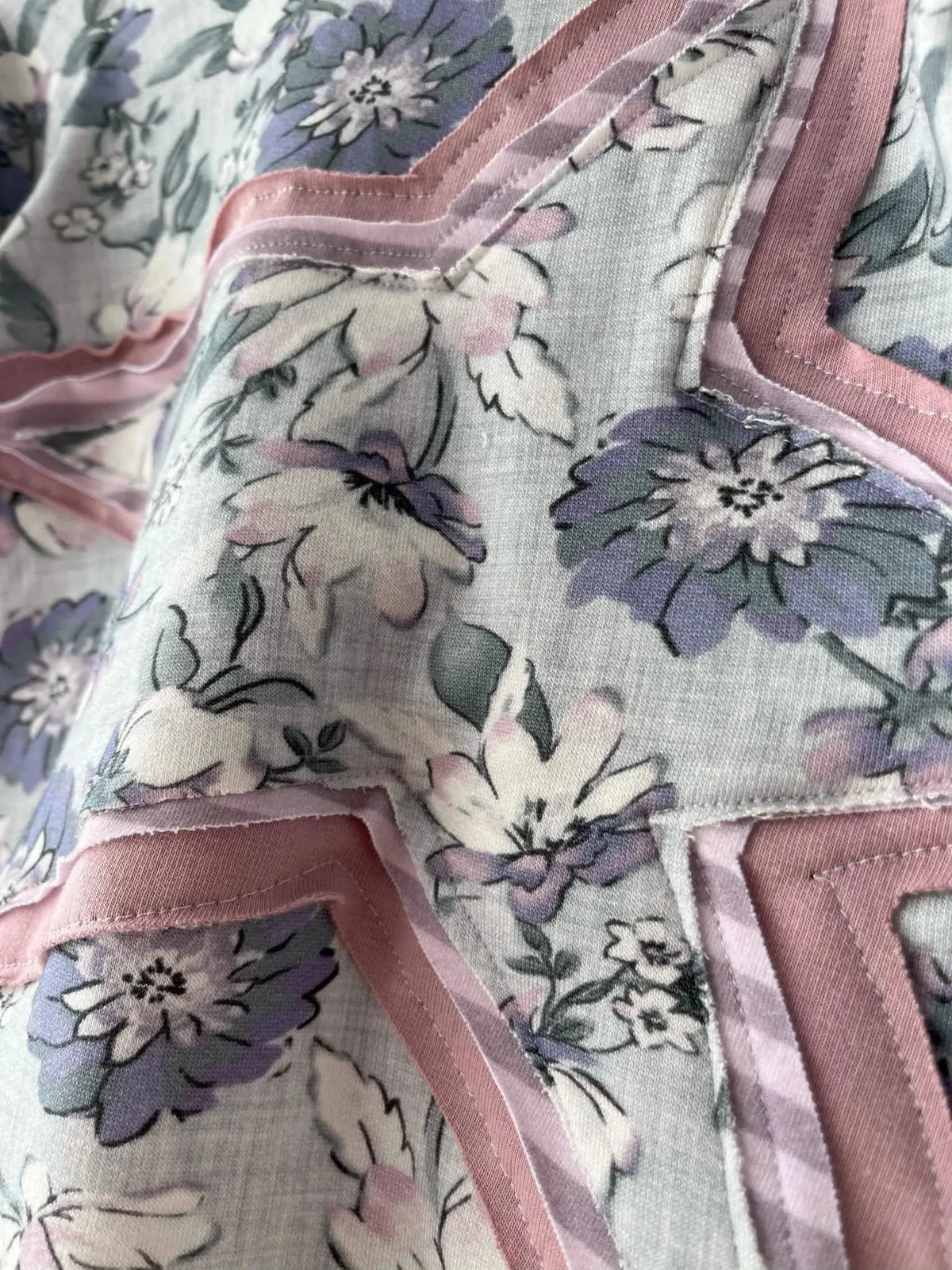 Cornflower Meadow Purple fabric with floral print and pink ribbon accents.