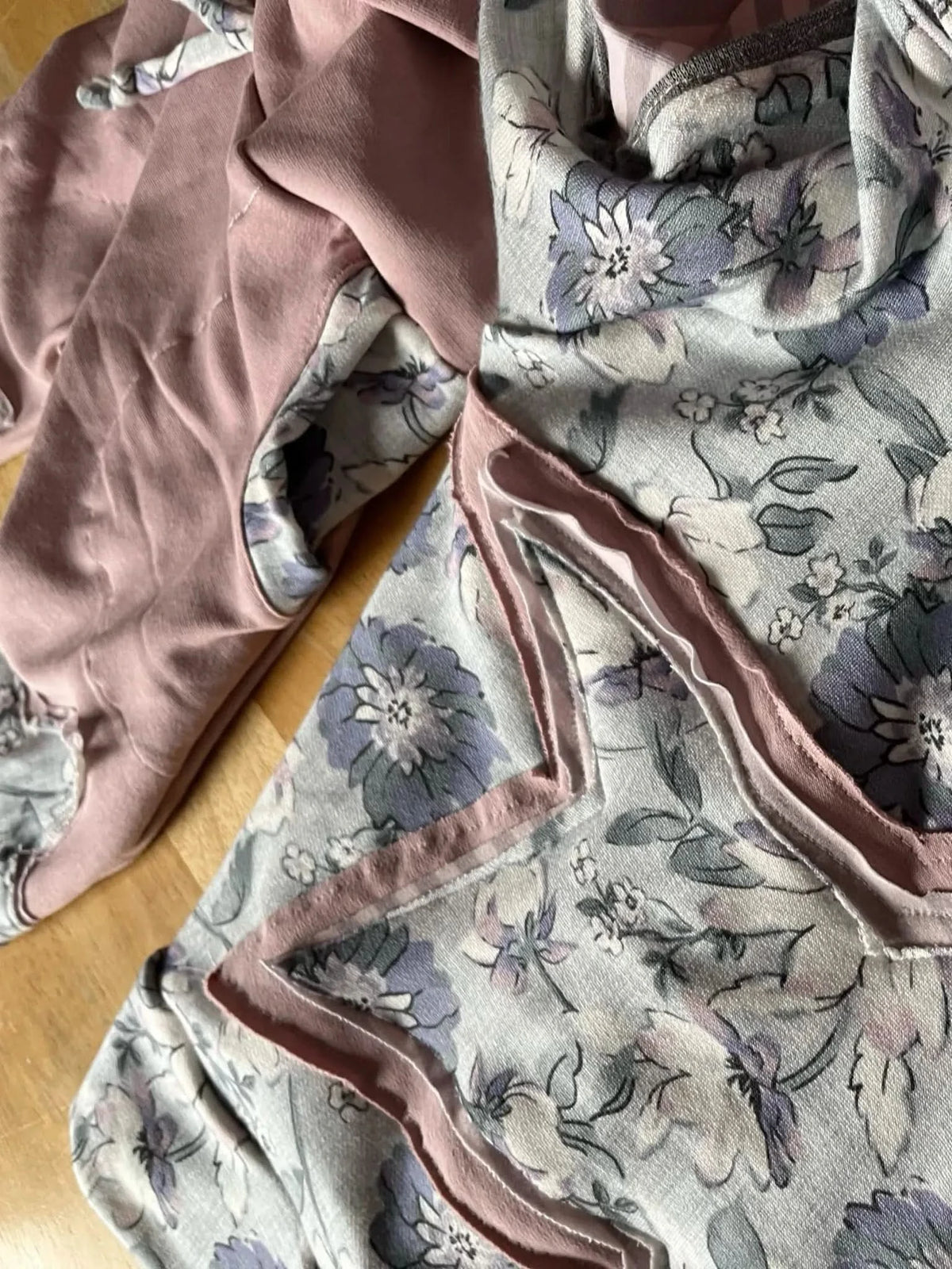 Fabric with a purple floral pattern and pink accents.