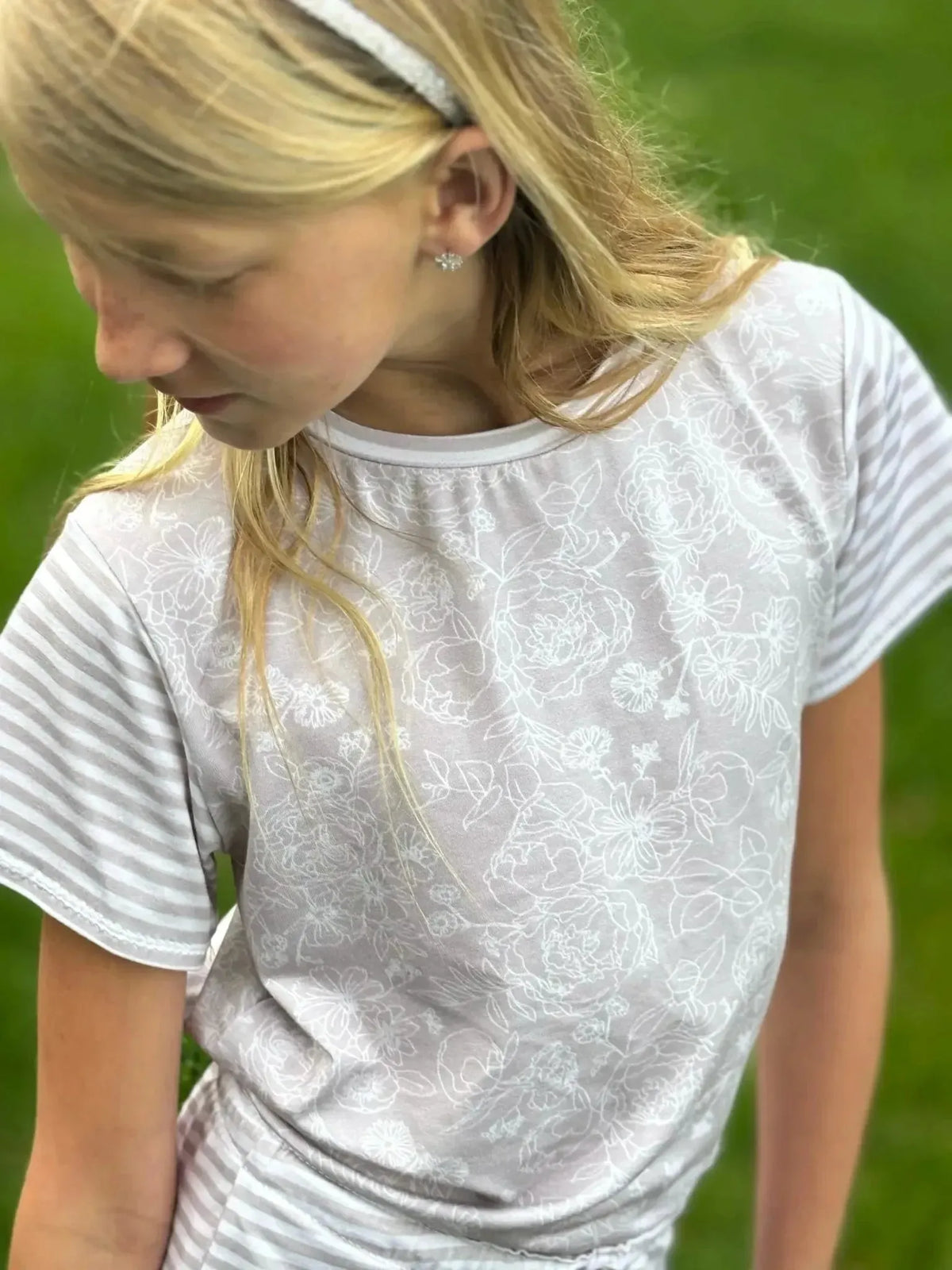 Tan stenciled floral print fabric in light beige with white rose patterns.